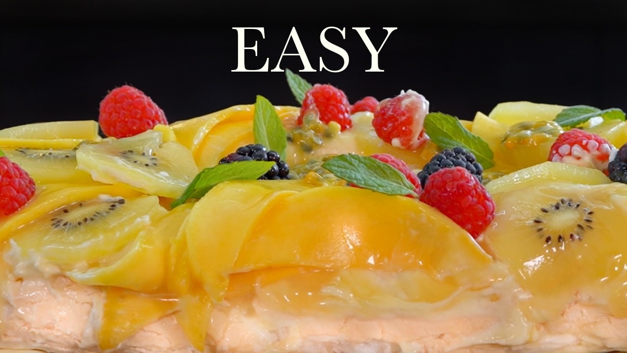 Tropical pavlova roll, a still from its video, with the channel name and the recipe title in text across it